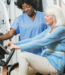 A physician directing a patient how to use a exercise machine.