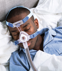 A man wearing a sleep anpnea mask while sleeping.